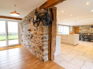 a room with a stone wall with a bike on it at Bwthyn Y Bugail Shepherd's Cottage in Oswestry