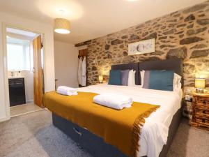 a bedroom with a large bed with a stone wall at Bwthyn Y Bugail Shepherd's Cottage in Oswestry
