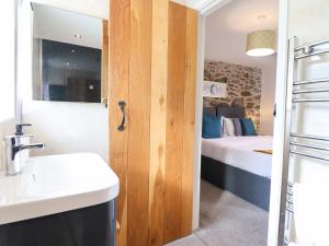 a bathroom with a sink and a door to a bedroom at Bwthyn Y Bugail Shepherd's Cottage in Oswestry +66 photos