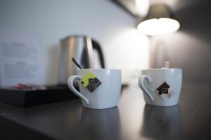 dos tazas de café sentadas en una encimera en Hostal Cabo Mayor, en Santander