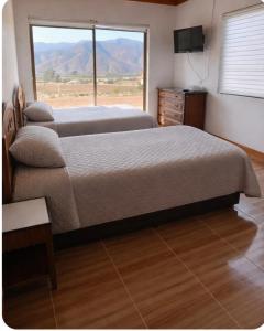 a bedroom with two beds and a large window at San José Hotel Boutique & Spa in La Ligua