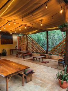 a patio with wooden tables and a staircase at Alya Jungle Casitas in San Juanillo