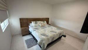 a bedroom with a bed with a wooden headboard at Cartagena Serena Del Mar INAWA in Cartagena de Indias