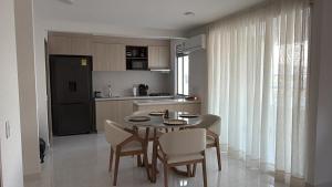 a kitchen with a table and chairs in a kitchen at Cartagena Serena Del Mar INAWA in Cartagena de Indias