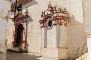 a building with a clock on the side of it at La Posada del Diezmo in Manzanilla
