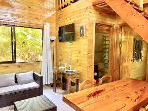 a wooden cabin with a table and a dining room at Finca Los Mangos in Manuel Antonio