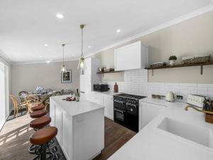 a kitchen with white appliances and a table with chairs at Aveline Cottage in Cessnock +13 photos