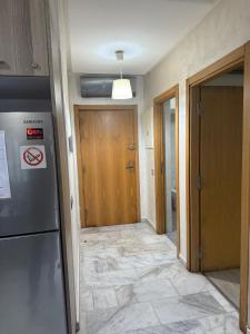 a room with a hallway with a refrigerator and a door at Appartement de lux avec piscine in Mohammedia
