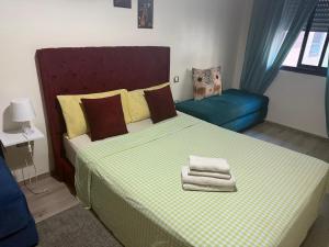 a bedroom with a bed and a blue couch at Appartement de lux avec piscine in Mohammedia