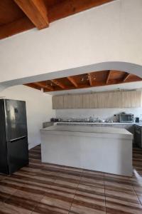 a kitchen with a white counter and a black refrigerator at San José Hotel Boutique & Spa in La Ligua