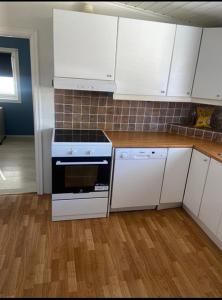 a kitchen with white cabinets and a stove at Hanaborg Appartments in Lorenskog