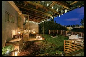 an outdoor patio with a wooden pergola at night at Hanaborg Appartments in Lorenskog