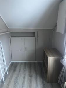 an attic room with a closet and a wooden desk at Hanaborg Appartments in Lorenskog +1 photo