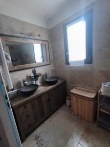 a bathroom with two sinks and a mirror at Jolie villa in Piolenc