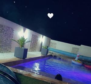 a swimming pool at night with a heart on the ceiling at Jolie villa in Piolenc