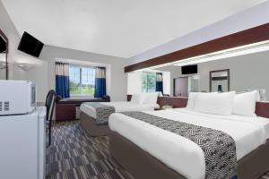 una camera d'albergo con due letti e una televisione di Microtel Inn & Suites by Wyndham London a London