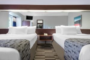 ロンドンにあるMicrotel Inn & Suites by Wyndham Londonのベッド2台と鏡が備わるホテルルームです。