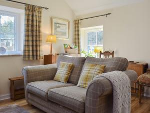 a living room with a couch and two pillows at Bonnie's Bothy in Port of Menteith