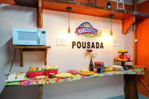 a table with food on it with a sign on a wall at Do Parque Pousada in Penha