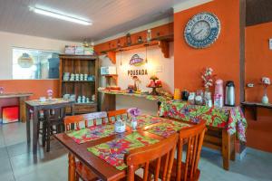 a dining room with a table and a clock on the wall at Do Parque Pousada in Penha