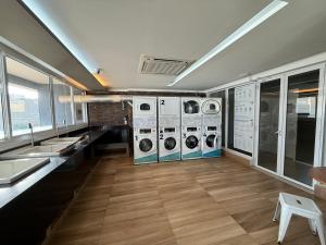 a laundry room with four washer and dryer machines at Flat Duo JK. Lindo e completo in Sao Jose do Rio Preto