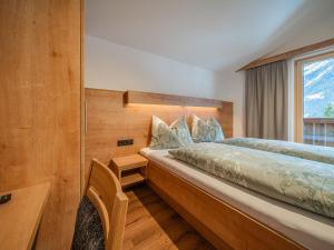 a bedroom with a large bed and a window at Glückauf in Krimml