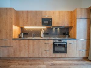 a kitchen with wooden cabinets and a sink and a stove at Glückauf in Krimml +12 photos