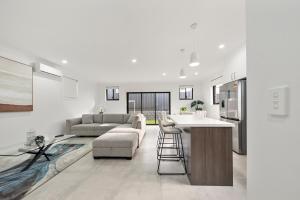 a kitchen and living room with a couch and a table at Gregory Hills Haven Luxe in Gledswood Hills
