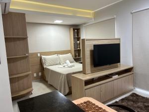 a small room with a bed and a flat screen tv at Flat Duo JK. Lindo e completo in Sao Jose do Rio Preto +18 photos