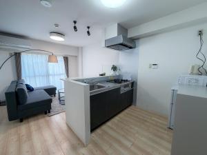 a kitchen with a sink and a couch in a room at BALCOM STAY Hiroshima Deshio in Hiroshima +46 photos