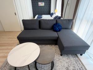 a living room with a couch and a table and a bed at BALCOM STAY Hiroshima Deshio in Hiroshima