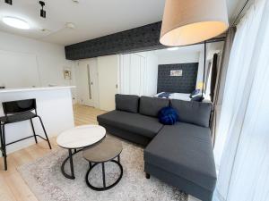 a living room with a couch and a table at BALCOM STAY Hiroshima Deshio in Hiroshima