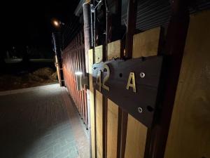 a sign on the side of a fence at night at Mehraz Guesthouse in Piet Retief