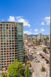a city with a tall building and a parking lot at Sub-Penthouse view condo in Downtown in Vancouver