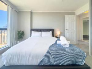 a bedroom with a large white bed and a window at The Enderley Escape in Gold Coast