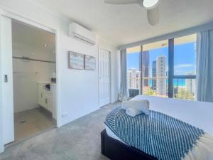 a white bedroom with a bed and a large window at The Enderley Escape in Gold Coast