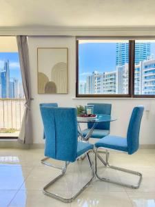 a dining room with blue chairs and a glass table at The Enderley Escape in Gold Coast +45 photos