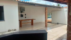 a patio with a wooden bench and a car parked at mendes in Água Boa