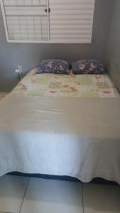 a bed with two pillows on top of it at mendes in Água Boa +1 photo