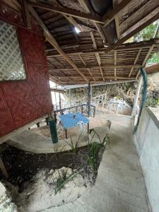a patio with a blue table under a roof at Gratum Beach 1 & 2 Resorts Glamping in Dapitan
