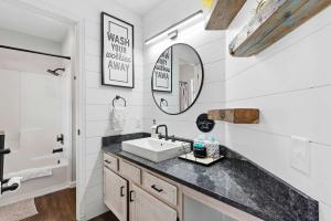 a bathroom with a sink and a mirror at TaneyCoMo Topia Quaint Studio in Branson