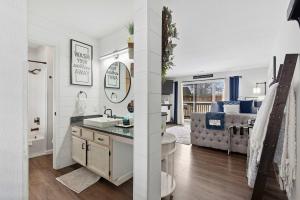 two images of a bathroom and a living room with a sink at TaneyCoMo Topia Quaint Studio in Branson