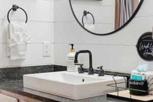 a white sink in a bathroom with a mirror at TaneyCoMo Topia Quaint Studio in Branson