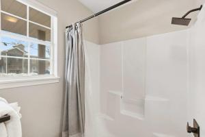 a bathroom with a shower curtain and a window at TaneyCoMo Topia Quaint Studio in Branson +14 photos