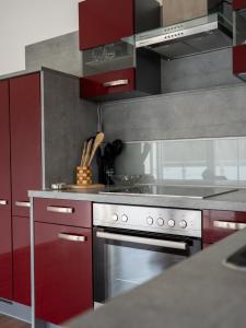 a kitchen with red cabinets and a white stove at Komfortresidenz Natur in Weiz