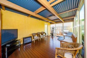 a living room with a flat screen tv and chairs at Brightside , Great family home near Airport in Craigieburn
