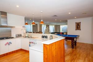 a kitchen with a sink and a pool table at Brightside , Great family home near Airport in Craigieburn