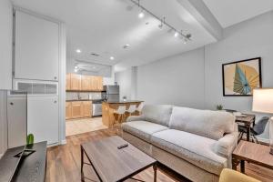 a living room with a couch and a kitchen at Central Downtown Condo | Parking & Pool Table in Cleveland