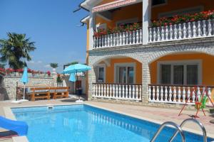 a house with a swimming pool in front of a building at Family-friendly apartments with swimming pool Nedescina, Central Istria - Sredisnja Istra - 7455 in Nedeščina