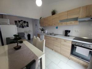 a kitchen with wooden cabinets and a table with a sink at Family-friendly apartments with swimming pool Nedescina, Central Istria - Sredisnja Istra - 7455 in Nedeščina